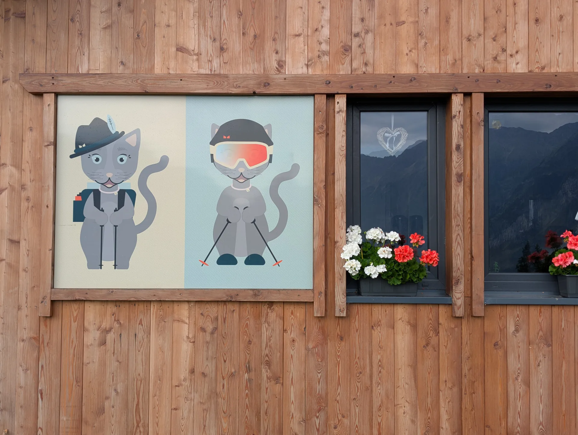 Tirolische Cartoon-Katzen-Wandbilder mit Geranien