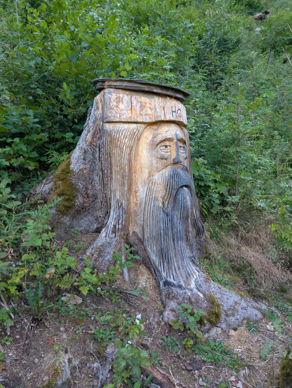 Bärtiger Berggeist als Baumstamm-Skulptur