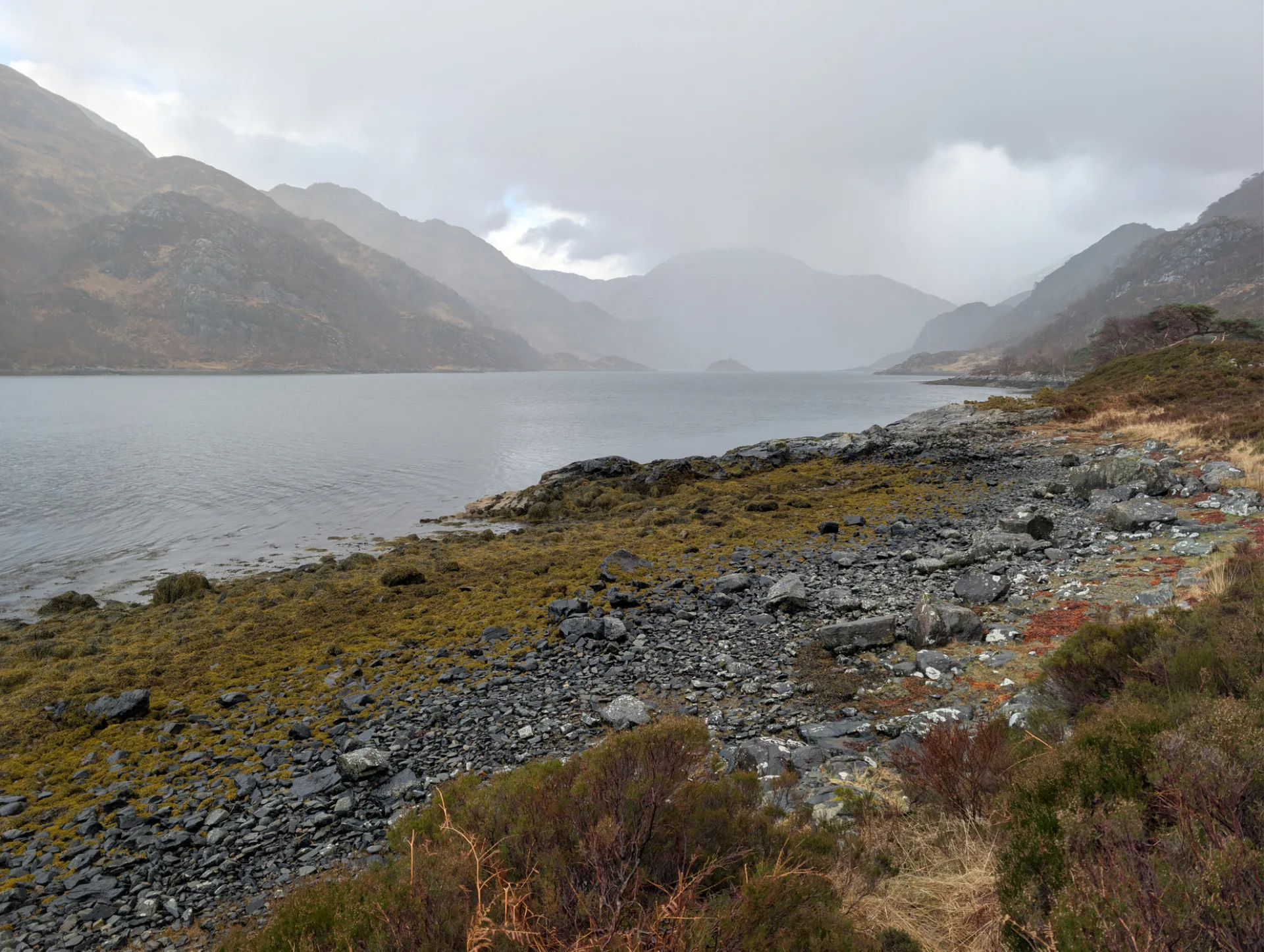 Loch-Strand unter dunklen Wolken