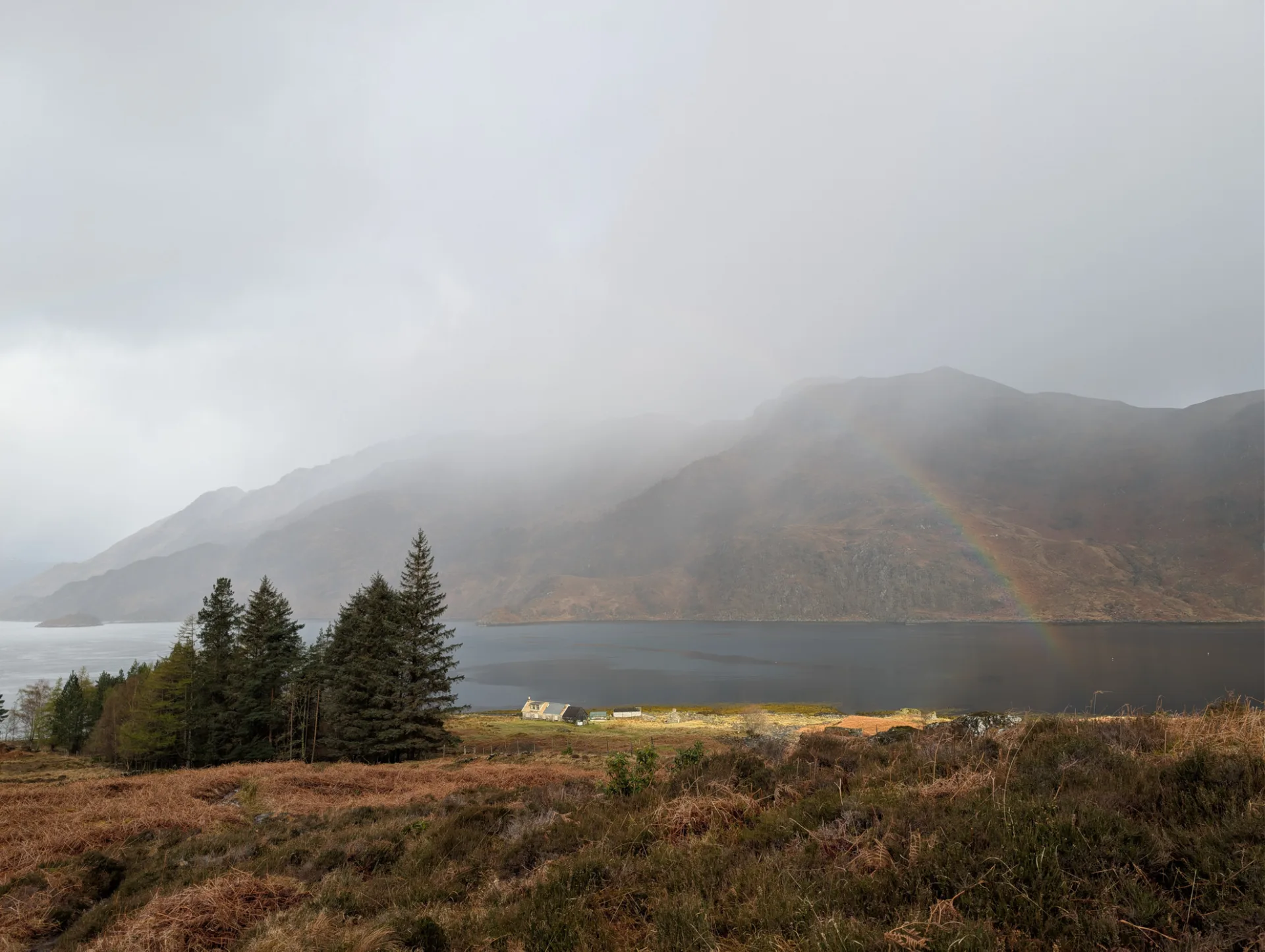 Regenbogen über dem Loch, ein einsames Haus am Ufer