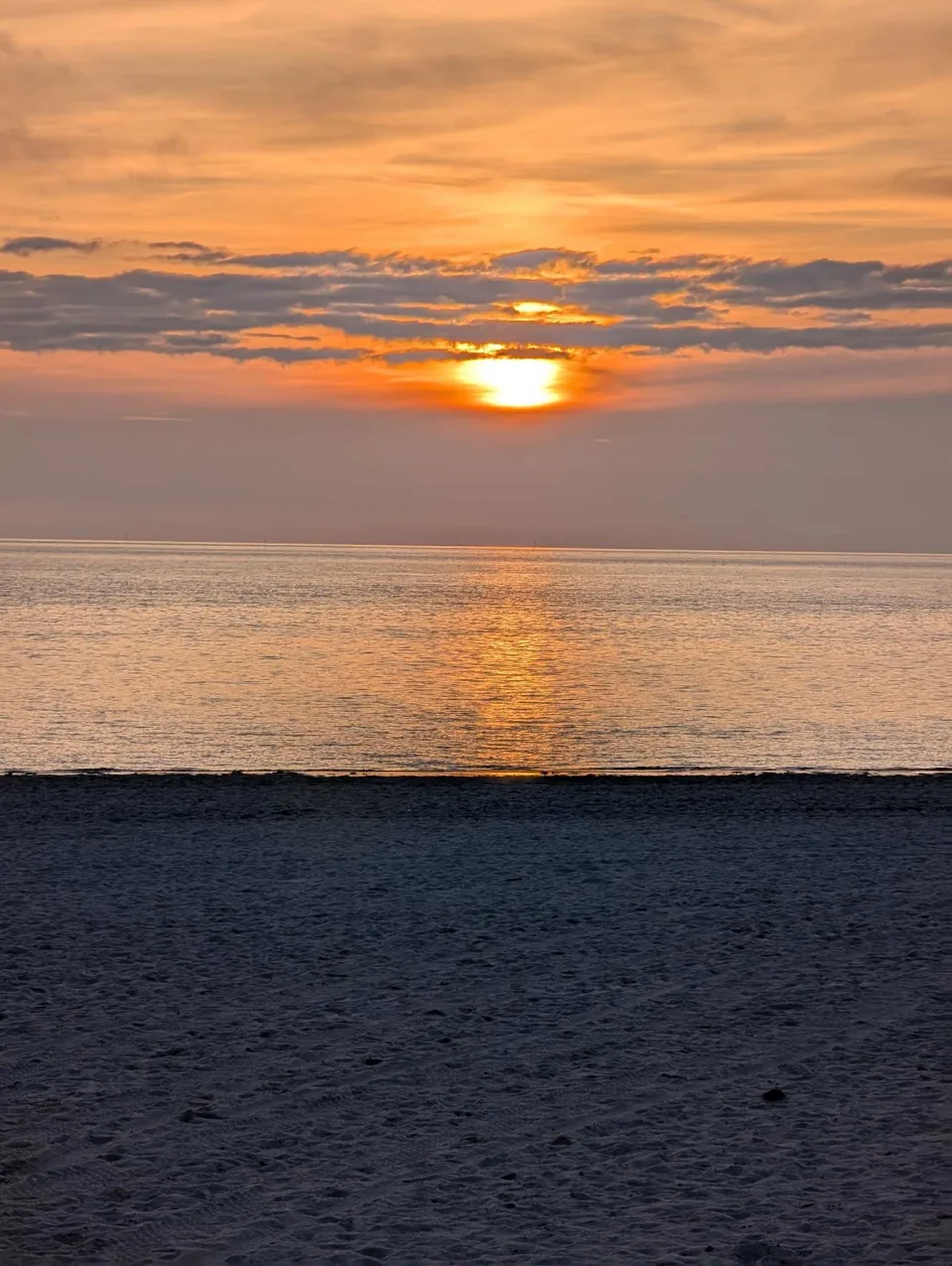 Sonnenuntergang überm Wattenmeer, der Strand schon im Schatten.