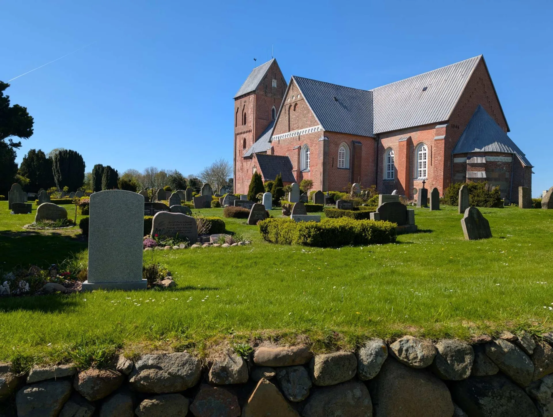 St. Johannis in Nieblum, der „Friesendom“ – eine der großen mittelalterlichen Backsteinkirchen Föhrs, mit altem Friesenfriedhof hinter der Feldsteinmauer.