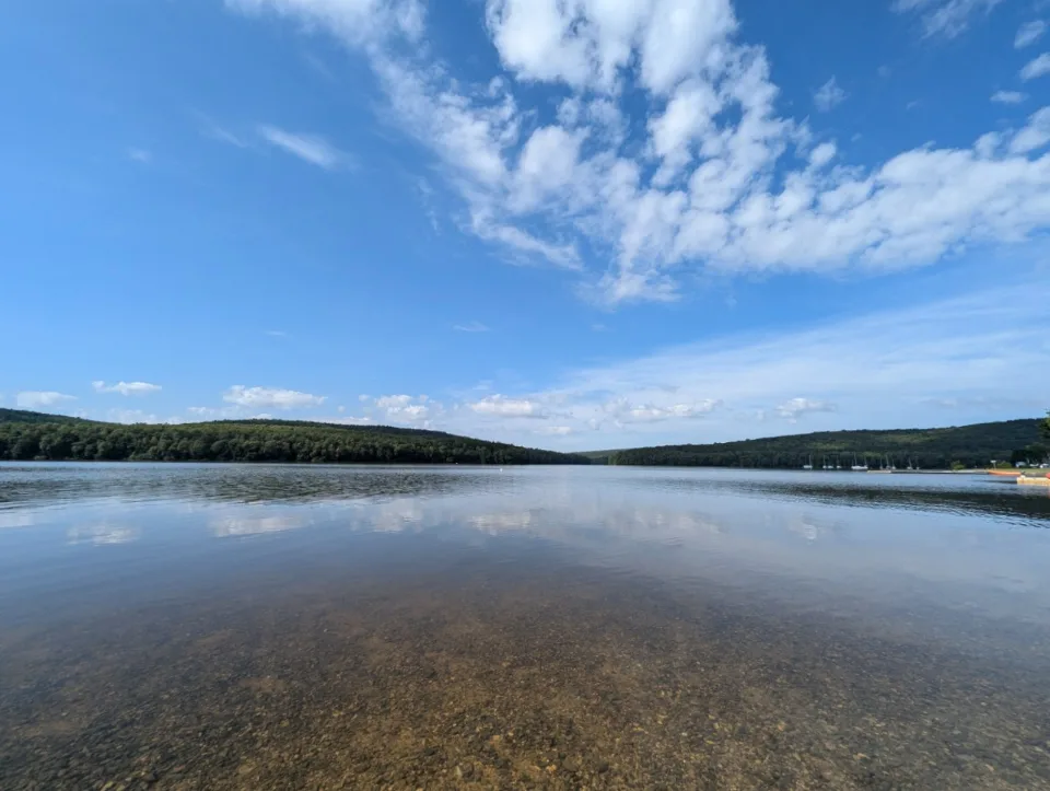 Weiter Blick über den Lac des Vieilles Forges, am Ufer ankern die ersten Segelboote.
