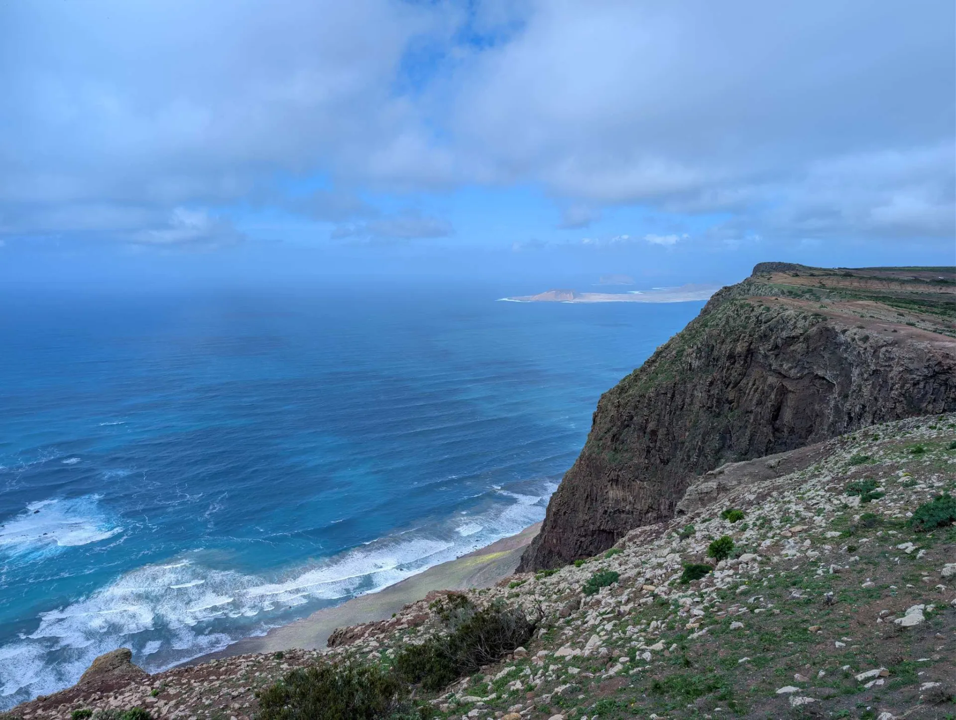 Hoch über dem Meer: der Risco de Famara fällt steil zum türkisen Wasser ab, am Horizont La Graciosa.