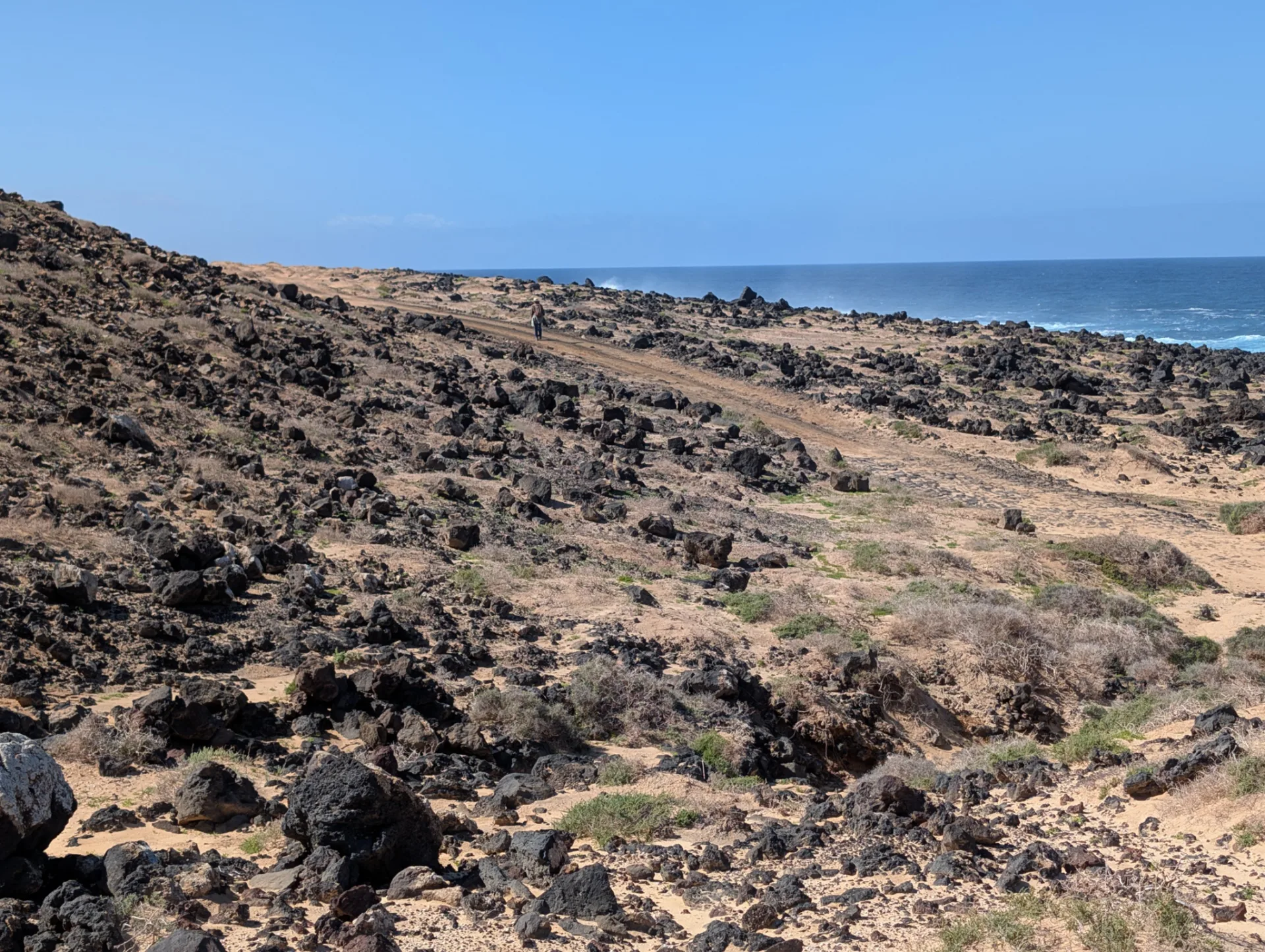 Vulkanfels auf La Graciosa, dahinter die Steilküste Lanzarotes.