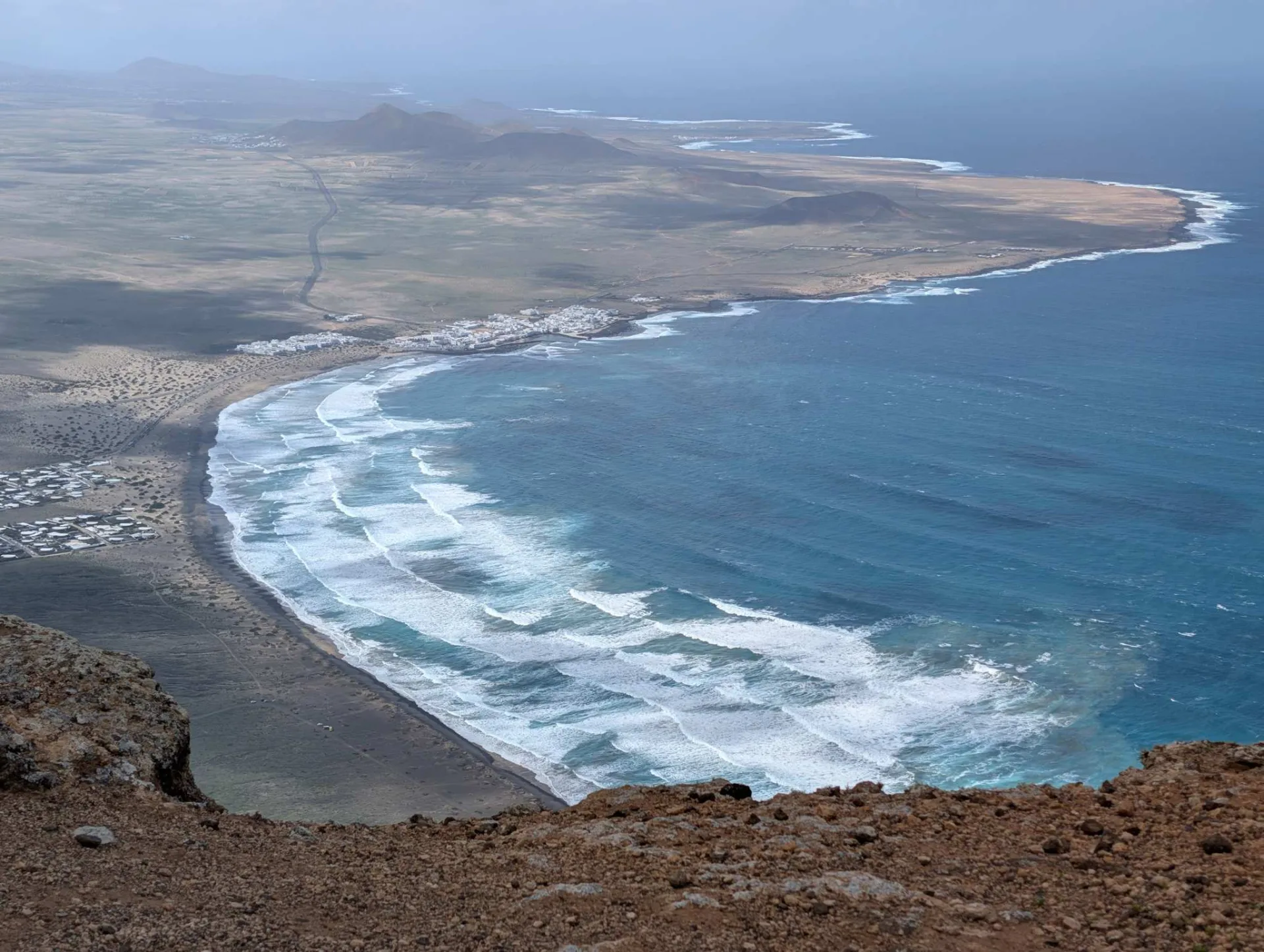 Der weite Bogen des Playa de Famara, tief unter den Klippen.