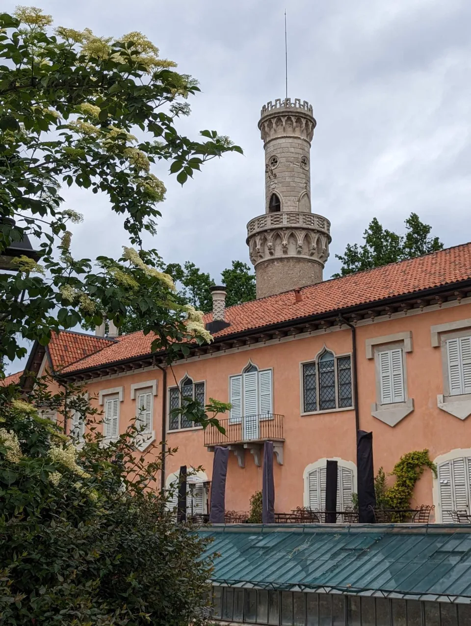 Neugotischer Rundturm über einer Villa am Rand der Gärten