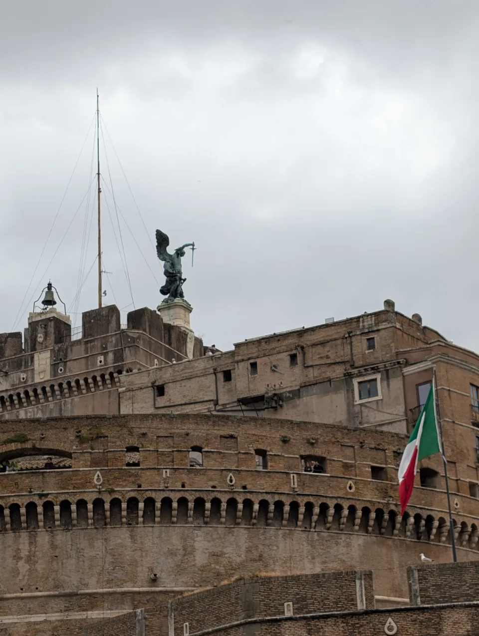 Engelsburg unter grauem Himmel, italienische Flagge im Wind