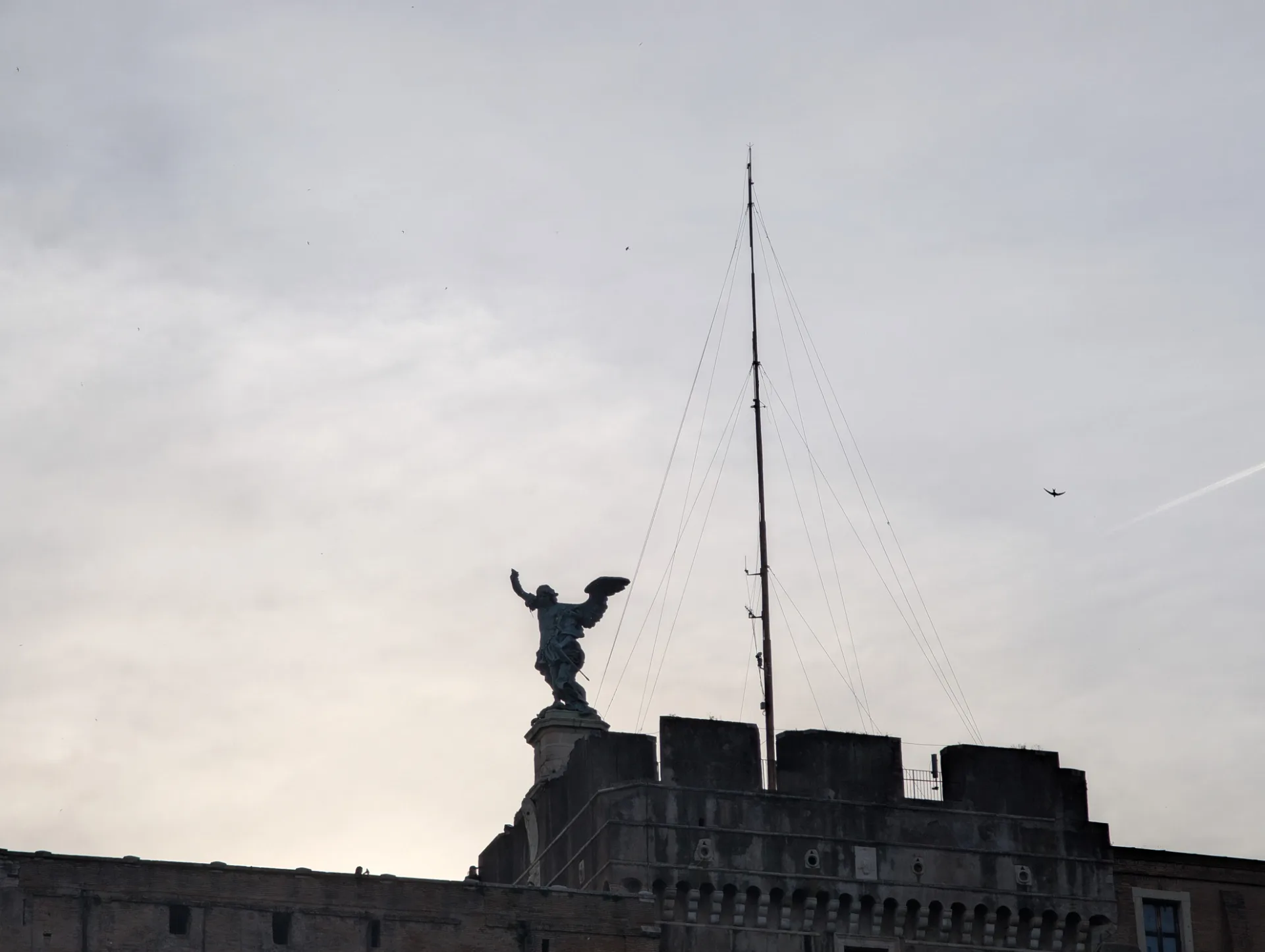 Engelsstatue auf der Engelsburg — Silhouette vor grauem Himmel