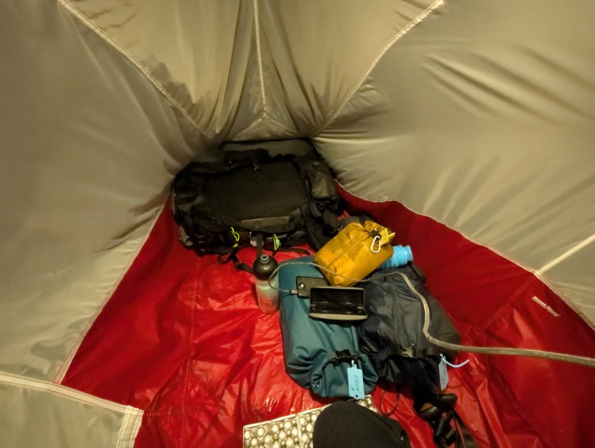 Zelt-Innenraum mit Rucksack, Wasserflasche und Equipment — fast alles trocken