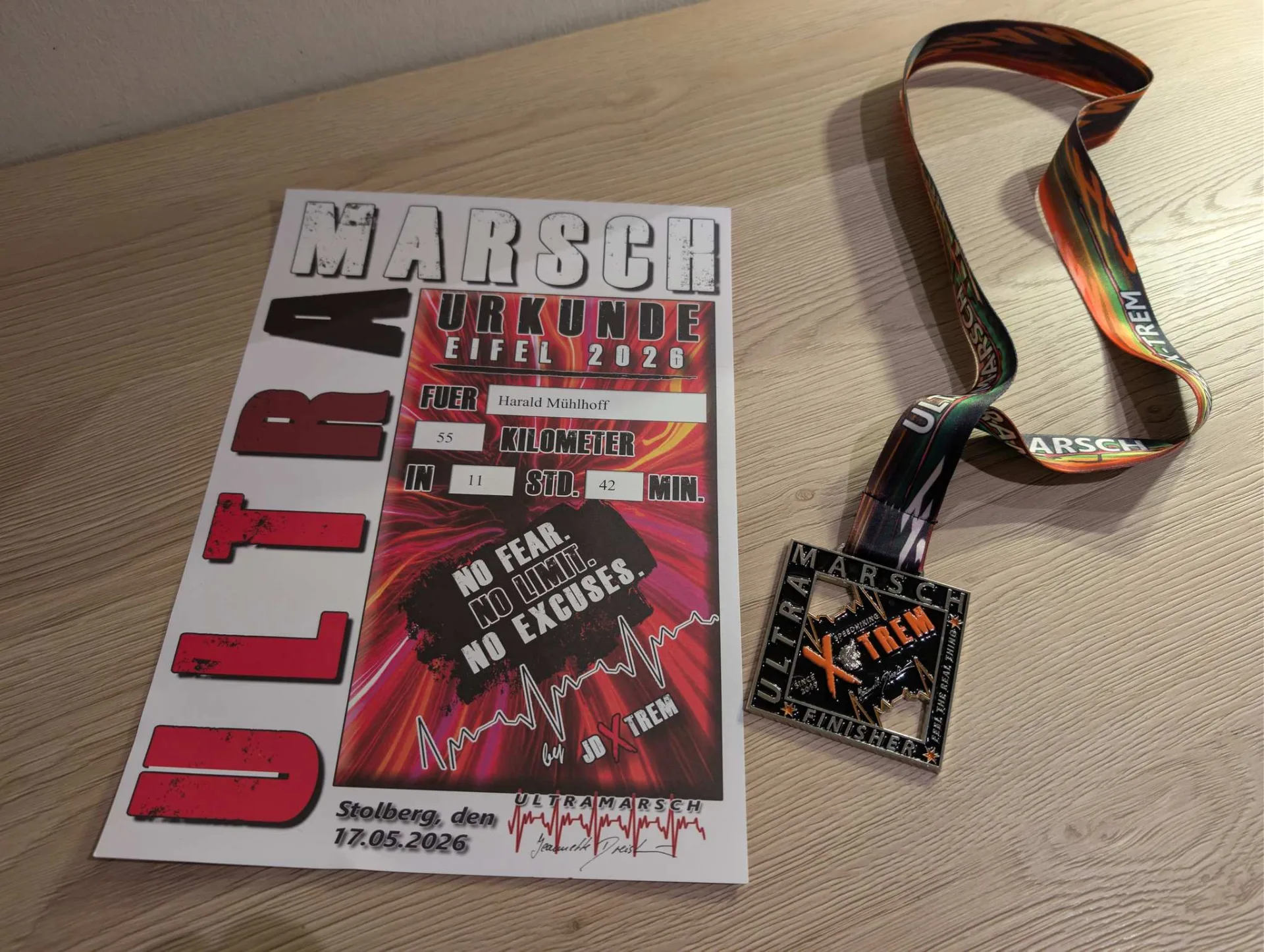 Im Ziel: Finisher-Urkunde und Medaille — 55 Kilometer in 11 Stunden 42 Minuten.